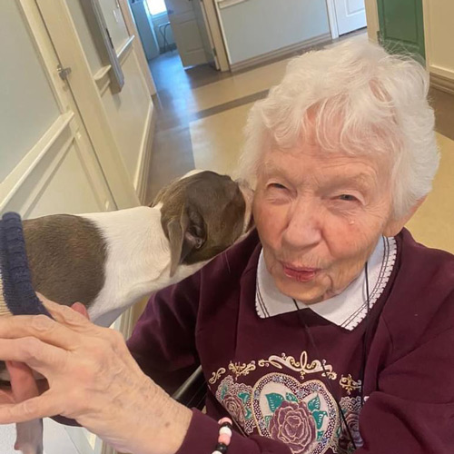 Resident enjoying a moment with a dog.