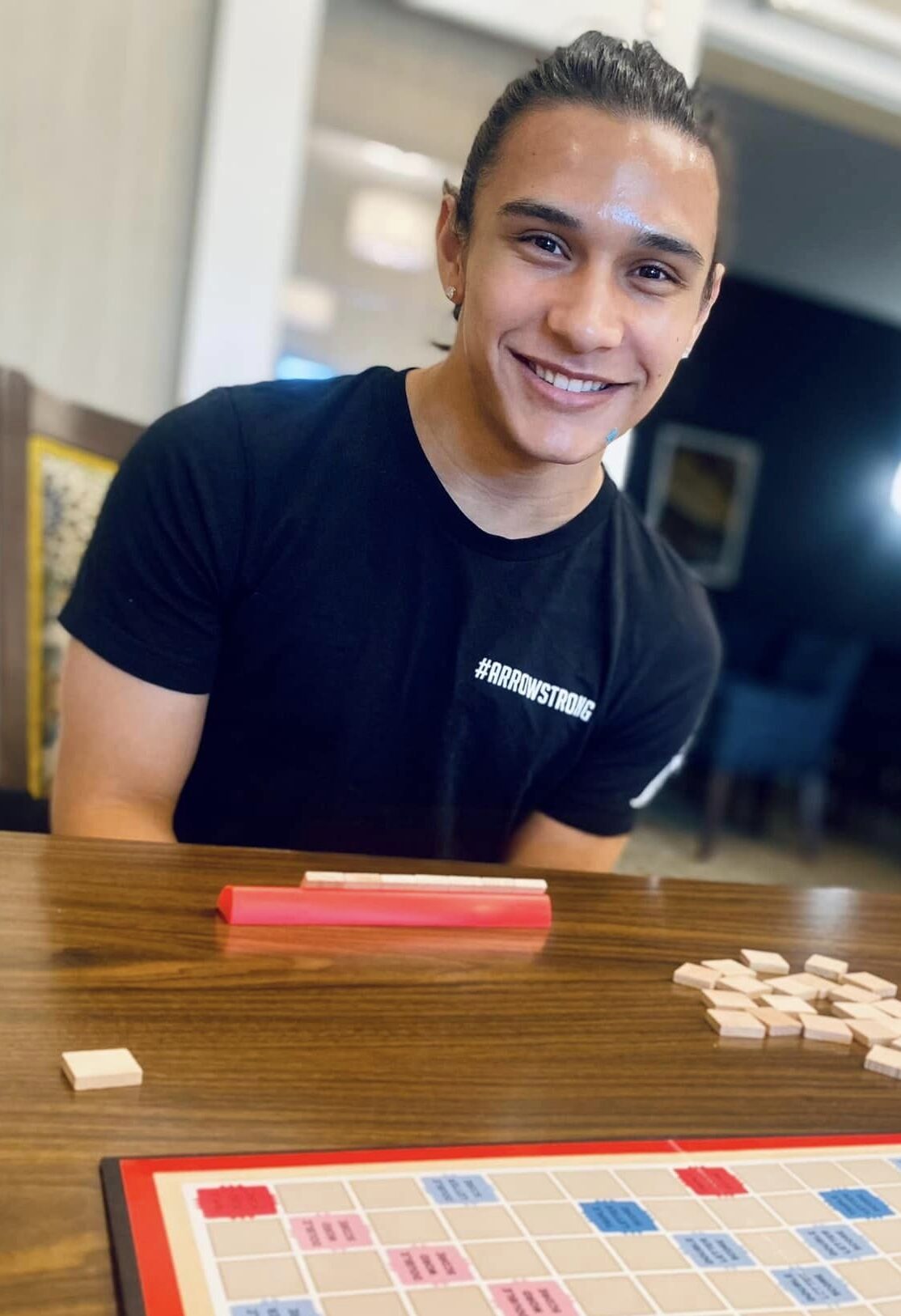 A smiling young man engaged in a game at a table