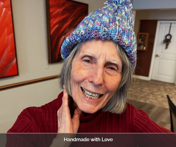 A smiling resident wearing a handmade hat