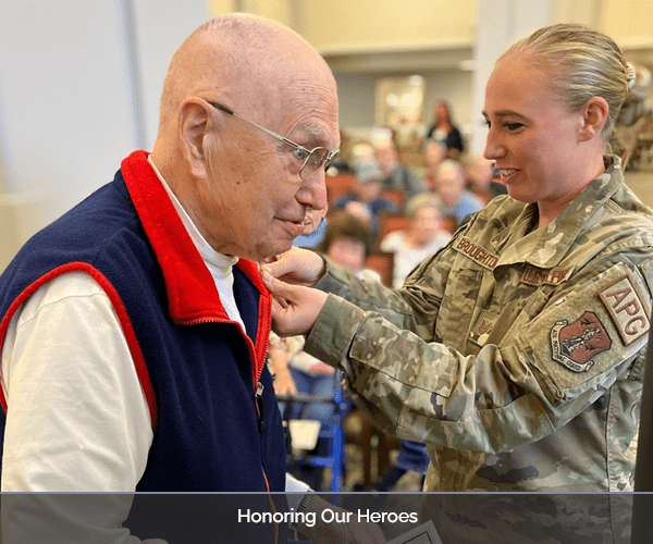 A veteran receiving recognition from a staff member in a ceremony