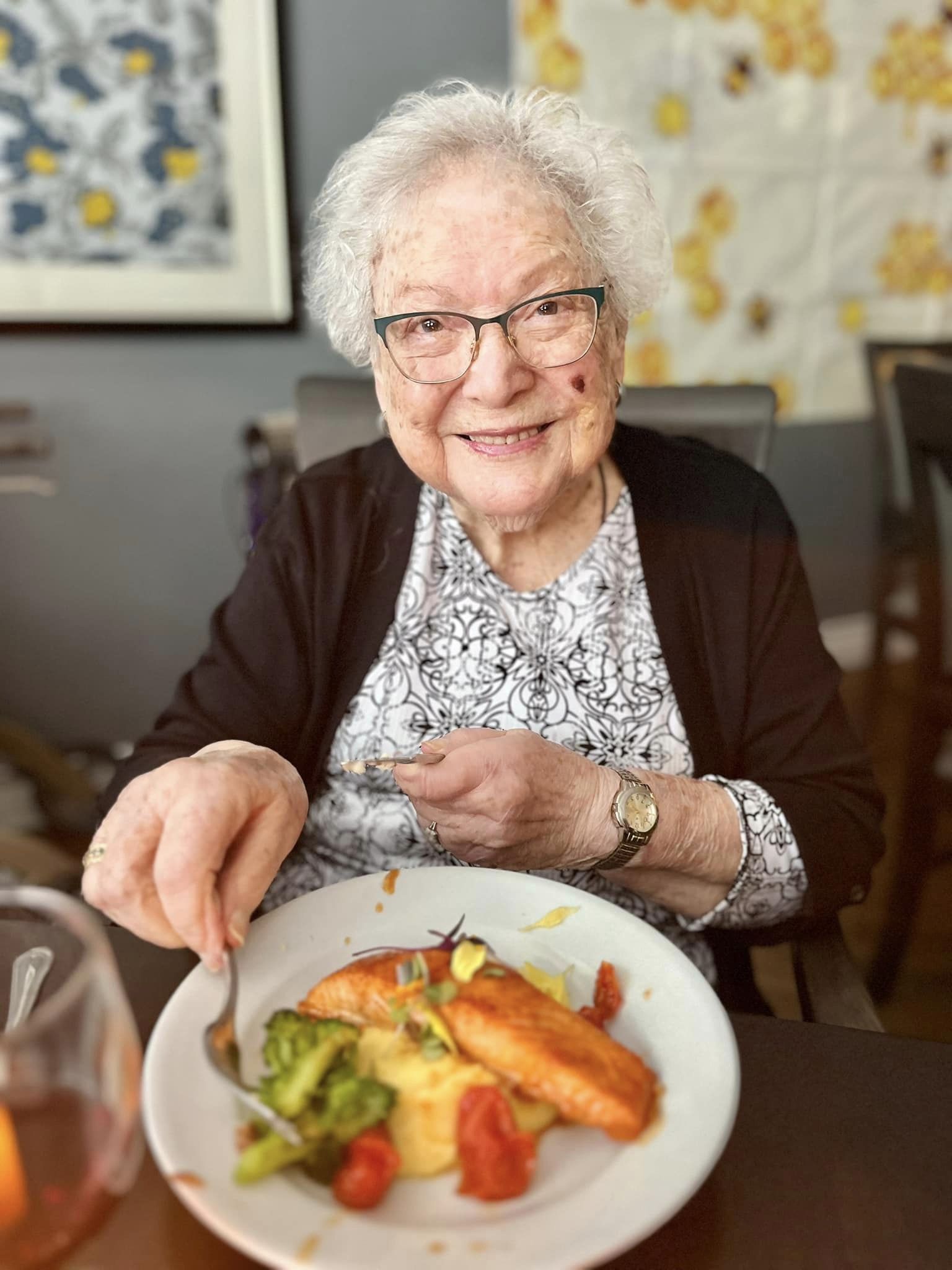 A resident enjoying a meal with salmon and vegetables