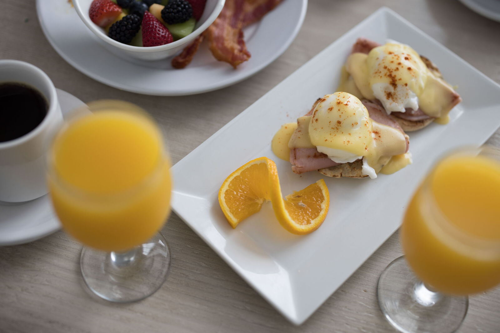 Delicious brunch spread with eggs benedict and fruit