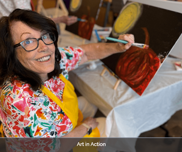 A resident painting on canvas during an art activity