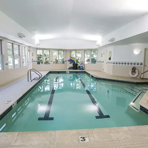 Indoor pool area with bright lighting and accessible features