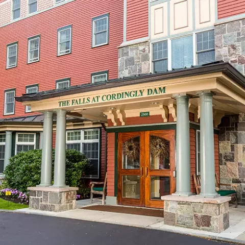 Front entrance of a senior living facility with stone and wood accents