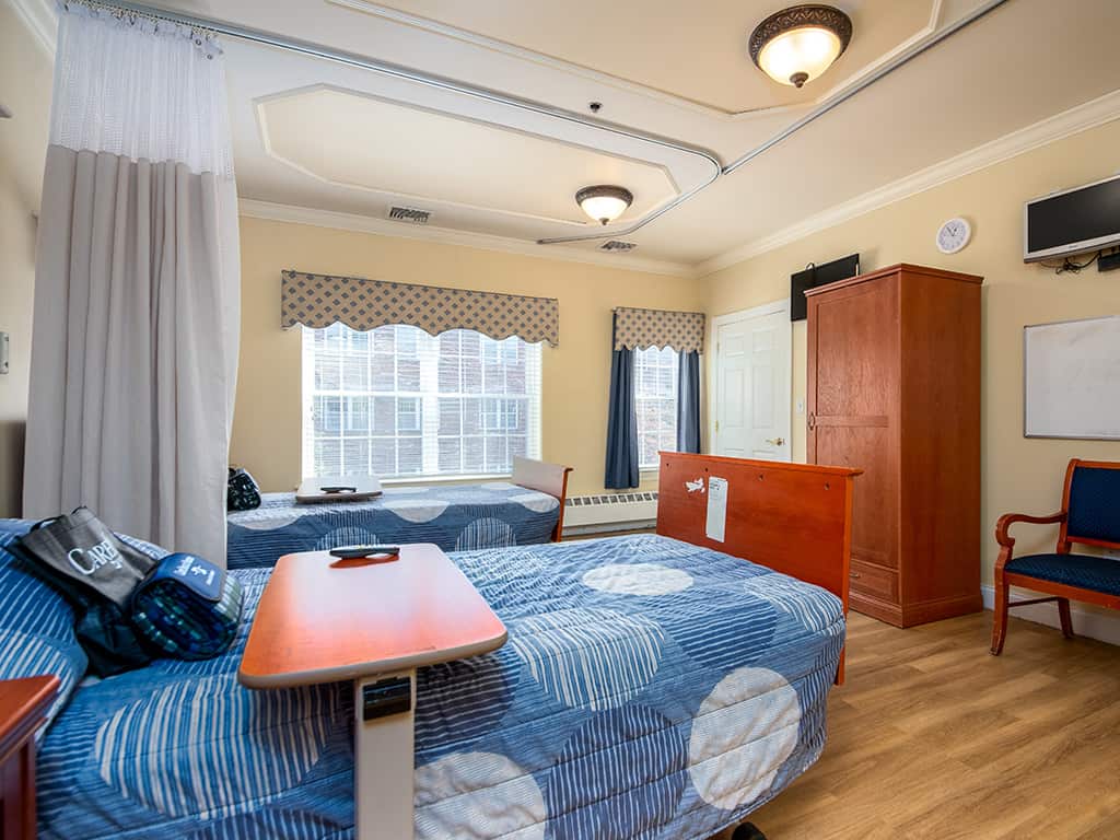 Resident room with two beds and natural light