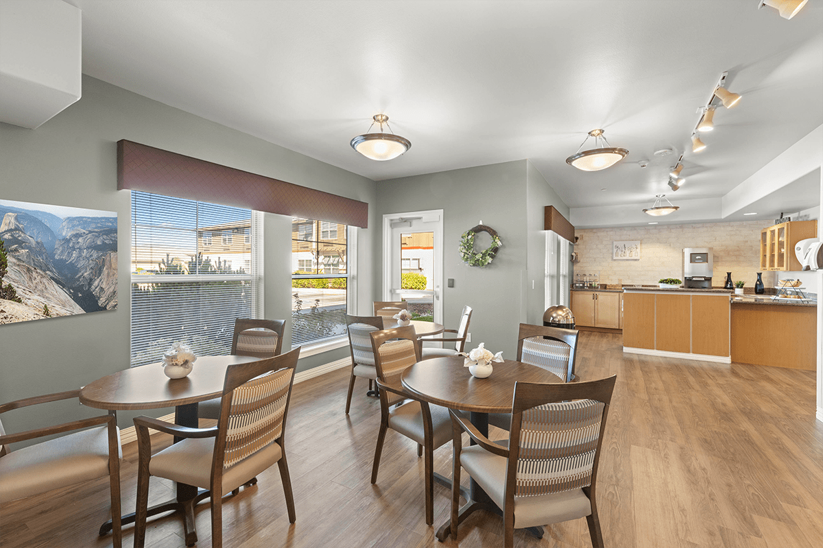 Bright common area with dining tables and kitchen visible