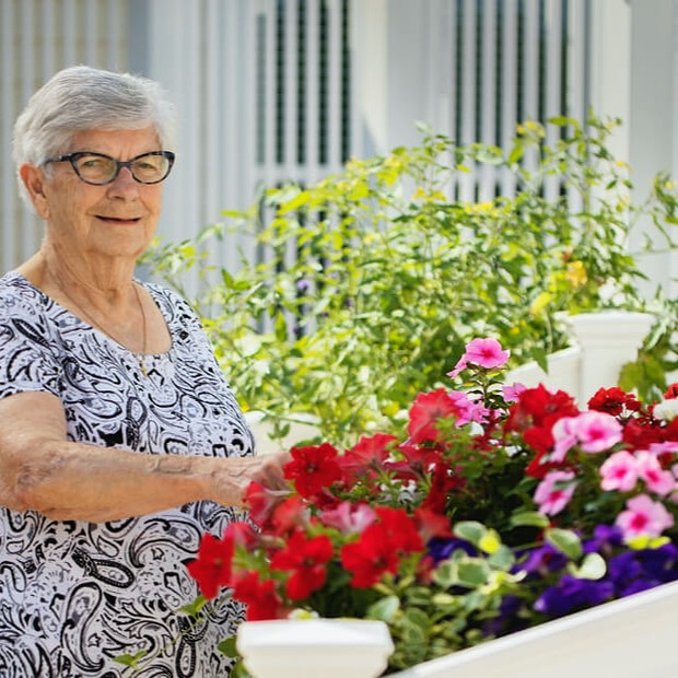 Senior woman tending to flowers in a garden