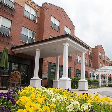 Exterior view of Benchmark Senior Living with flowers