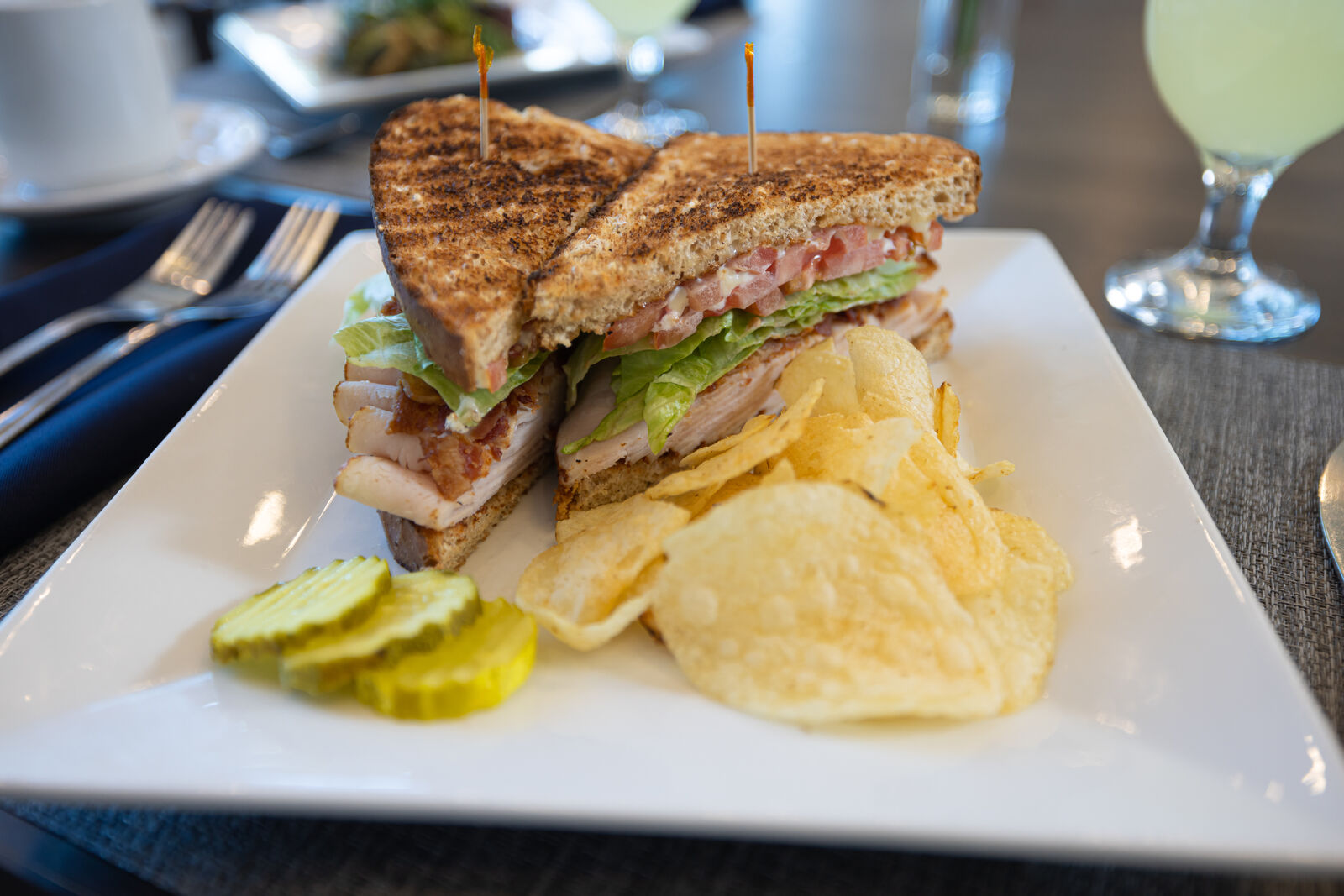 Close-up of a sandwich with chips and pickles