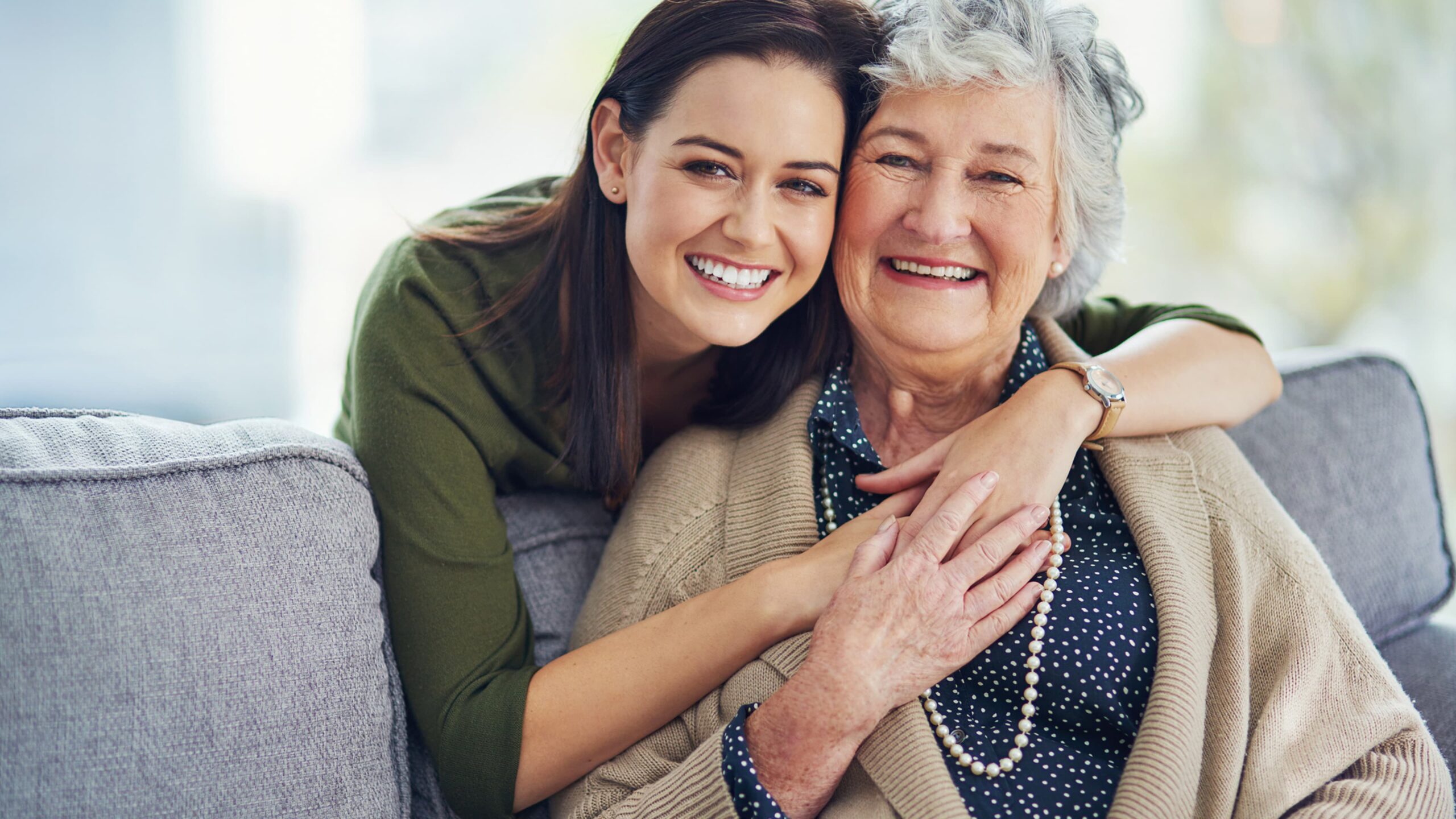 A caregiver and a senior resident smiling together