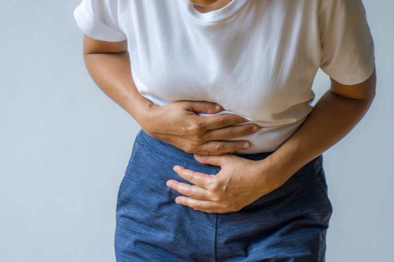 Person holding their stomach, indicating discomfort