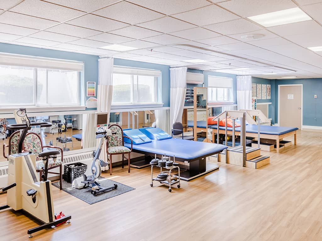 Physical therapy room with equipment and tables