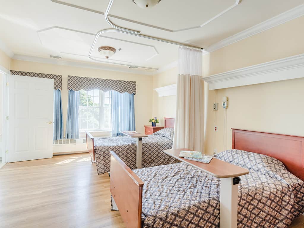 Shared resident room with two beds and natural lighting