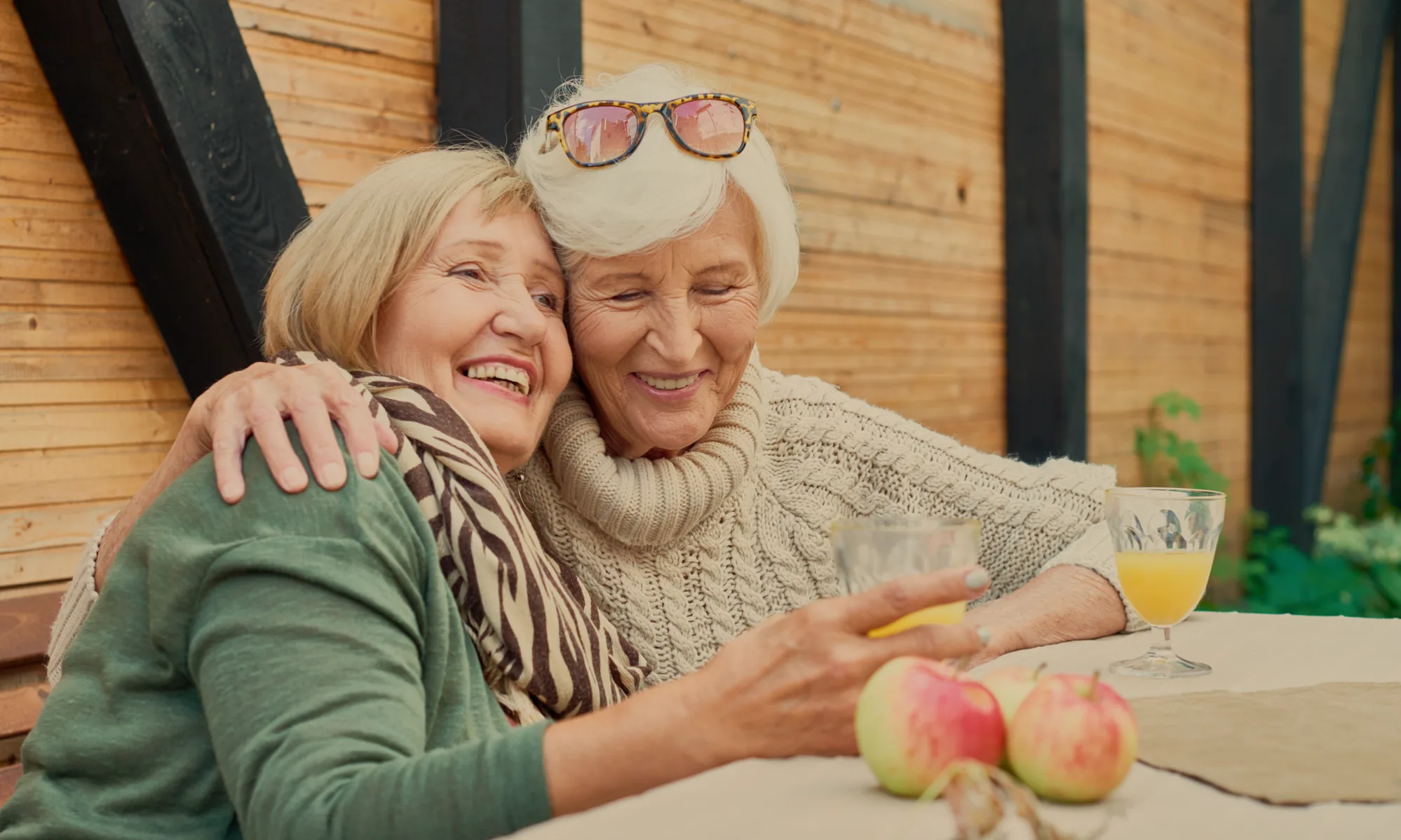 Two senior women enjoying time together with apples on the table