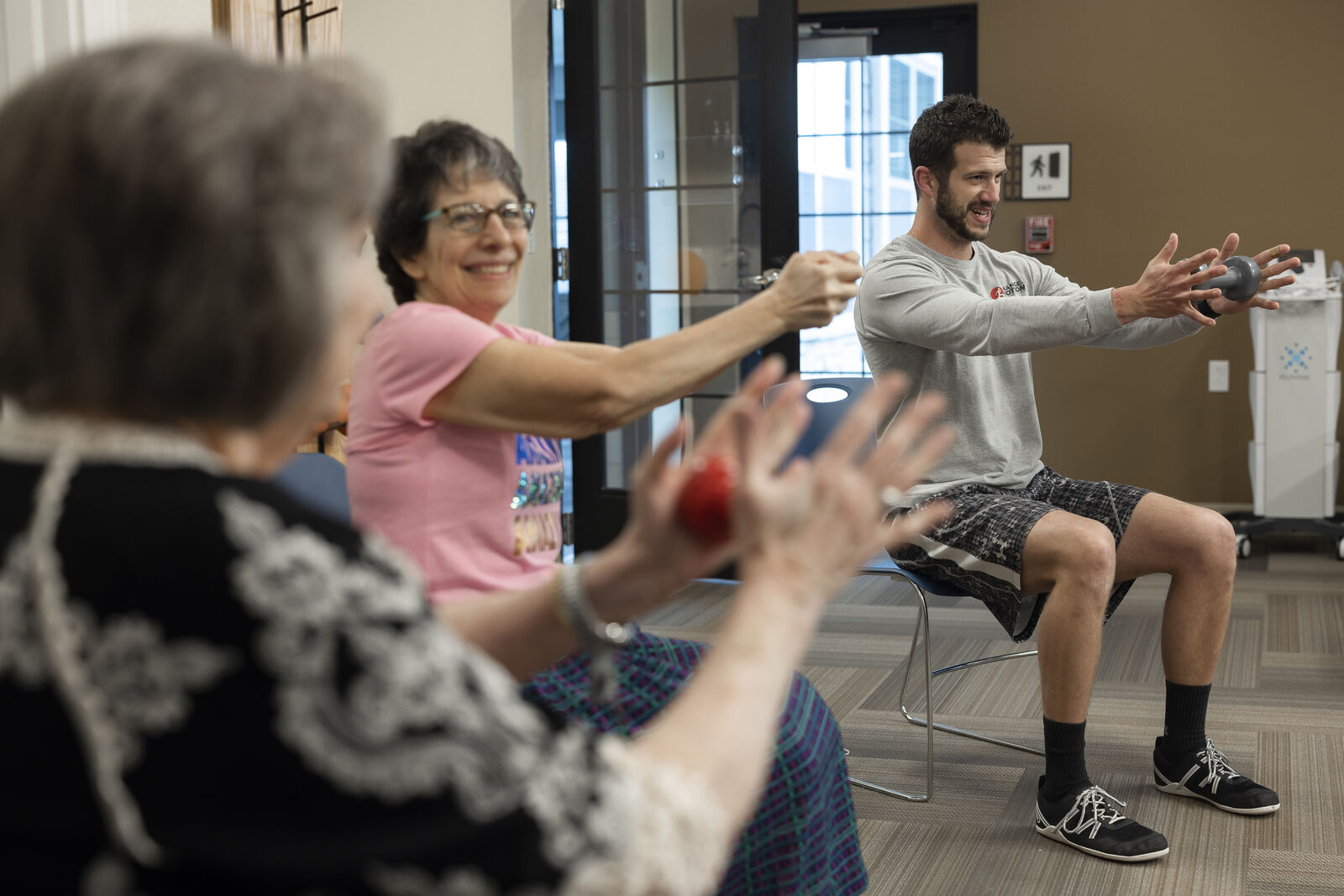 Residents participating in a fitness activity in a common room