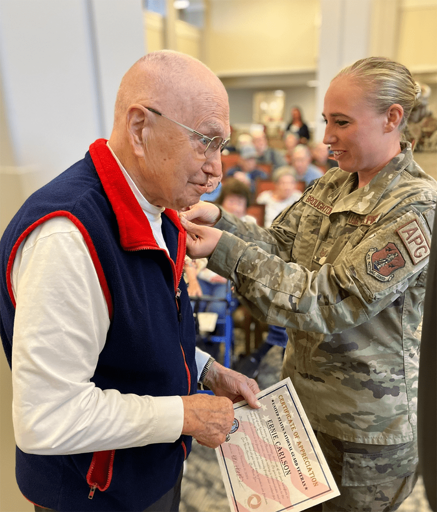 A resident receiving a certificate from a military personnel