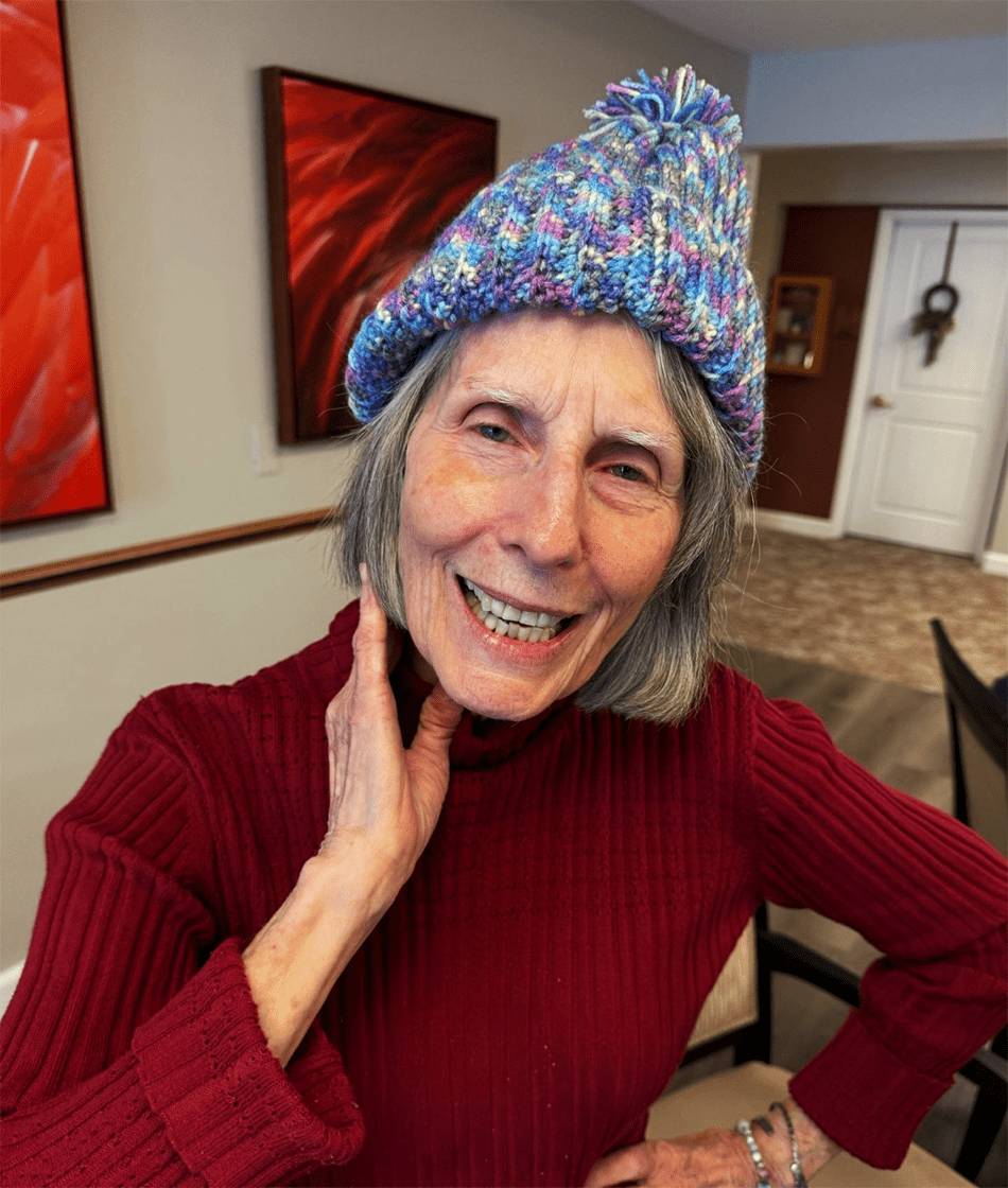 Senior resident wearing a colorful knitted hat and smiling