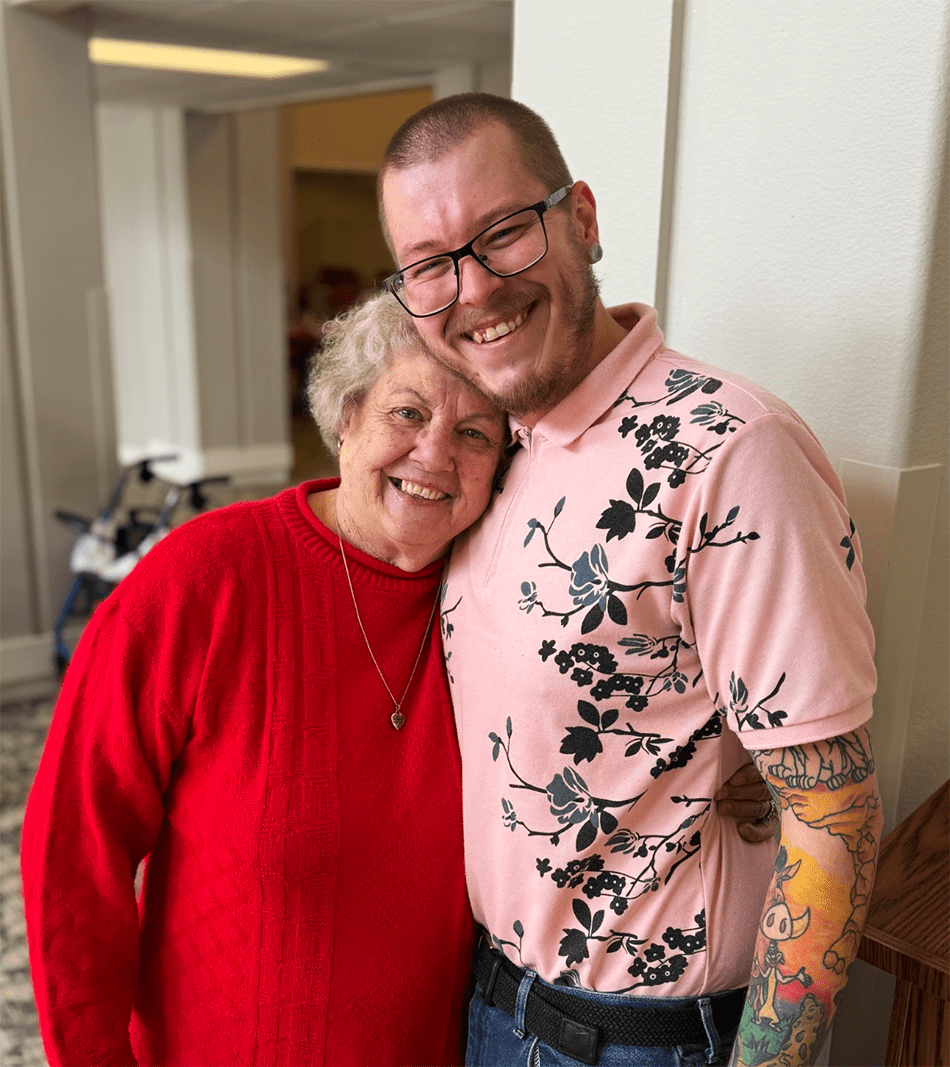 Resident and staff member smiling together in a common area