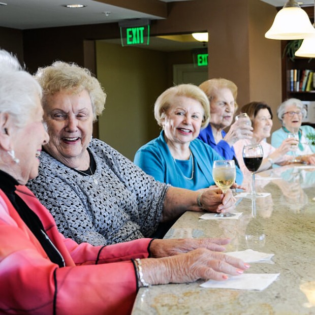 Residents enjoying drinks and laughter in a social setting