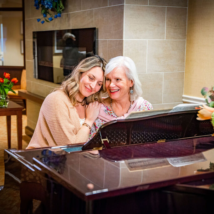 Residents enjoying music together at a piano