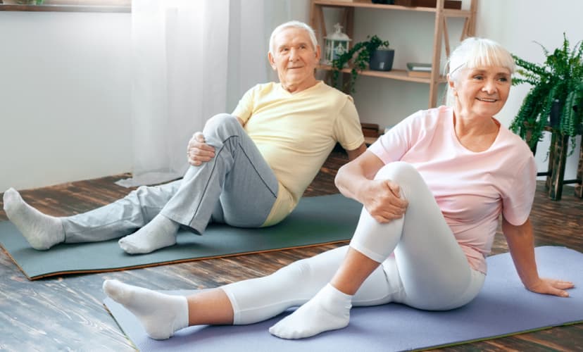 Two seniors exercising in a bright activity room