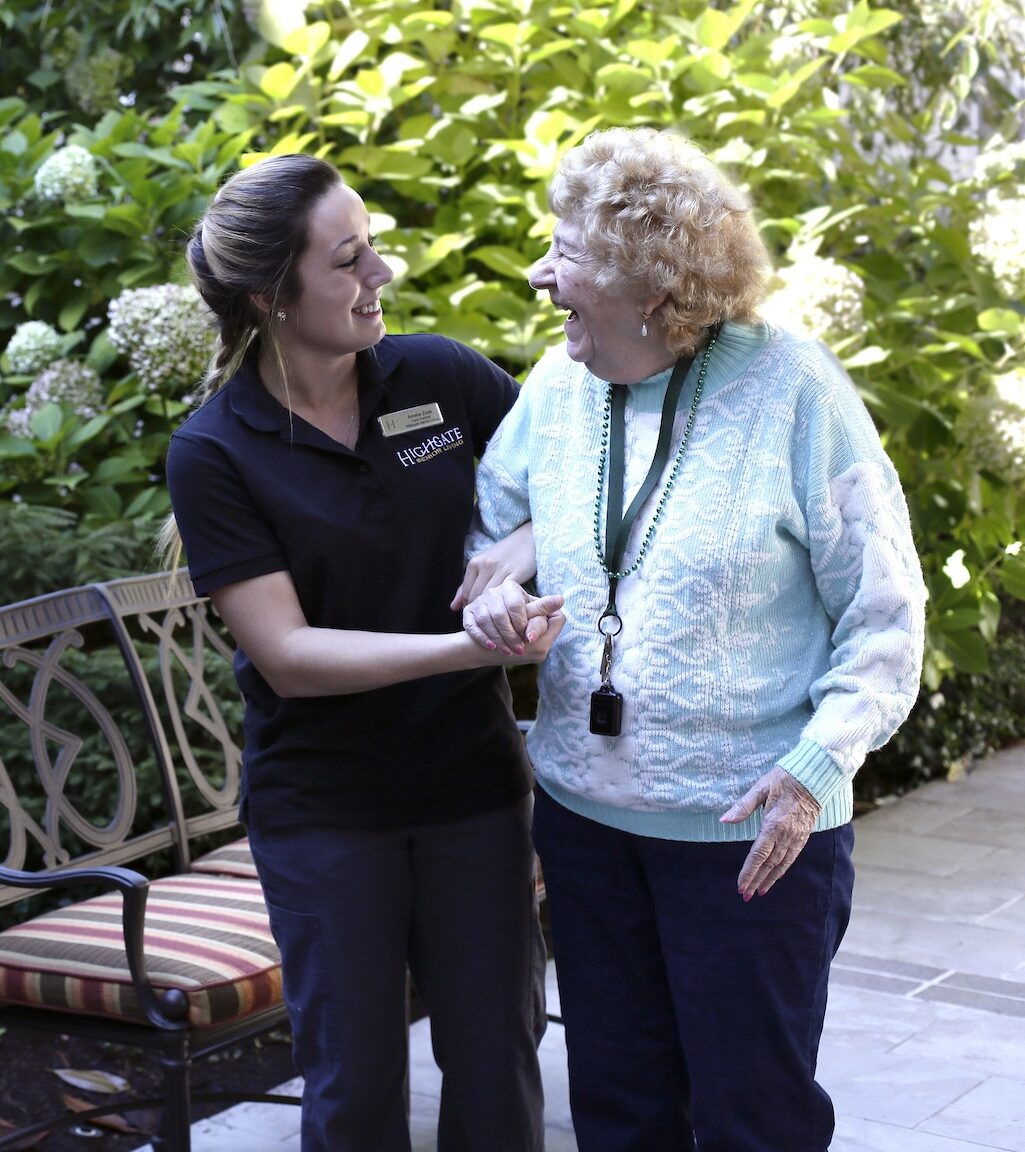 Staff member assisting a resident outdoors in a garden