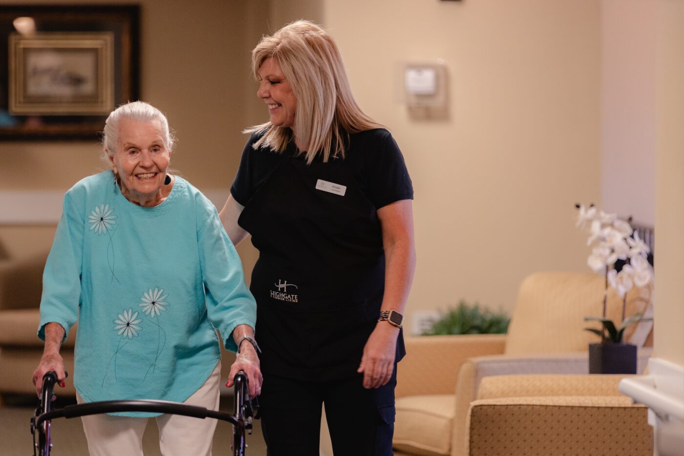 A staff member assisting a resident in a hallway