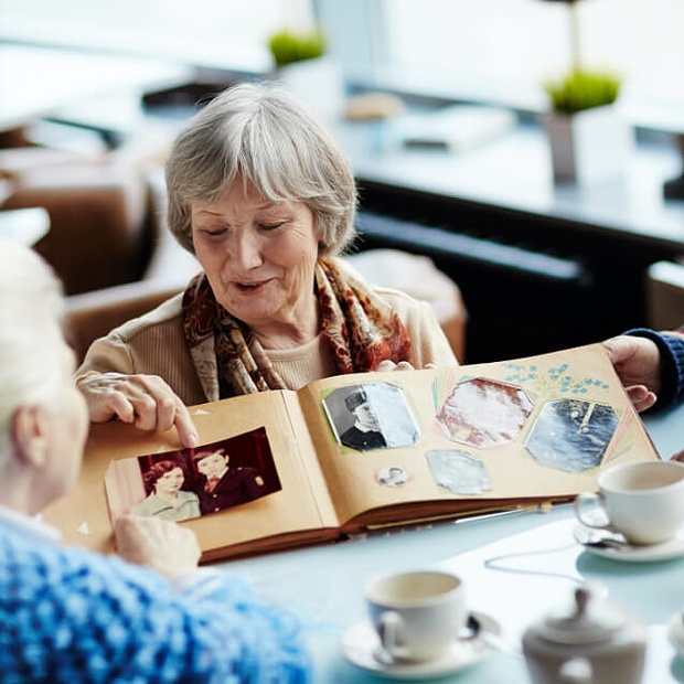A resident sharing a photo album with another guest