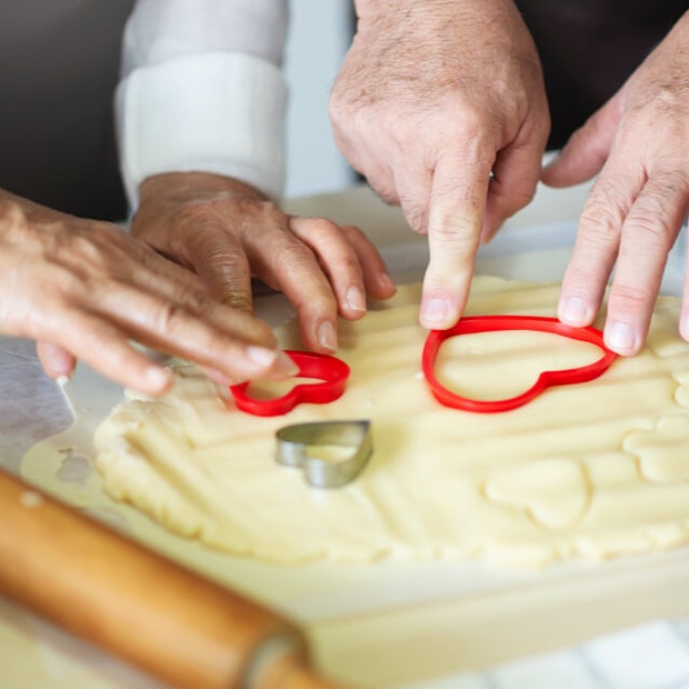 Residents baking cookies with heart-shaped cutters
