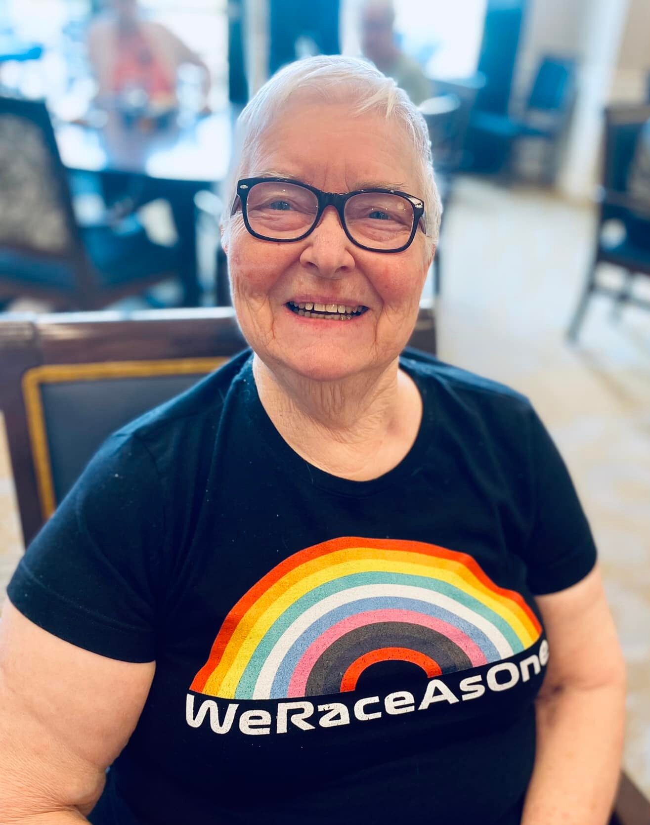 Resident smiling in a common area with a colorful shirt