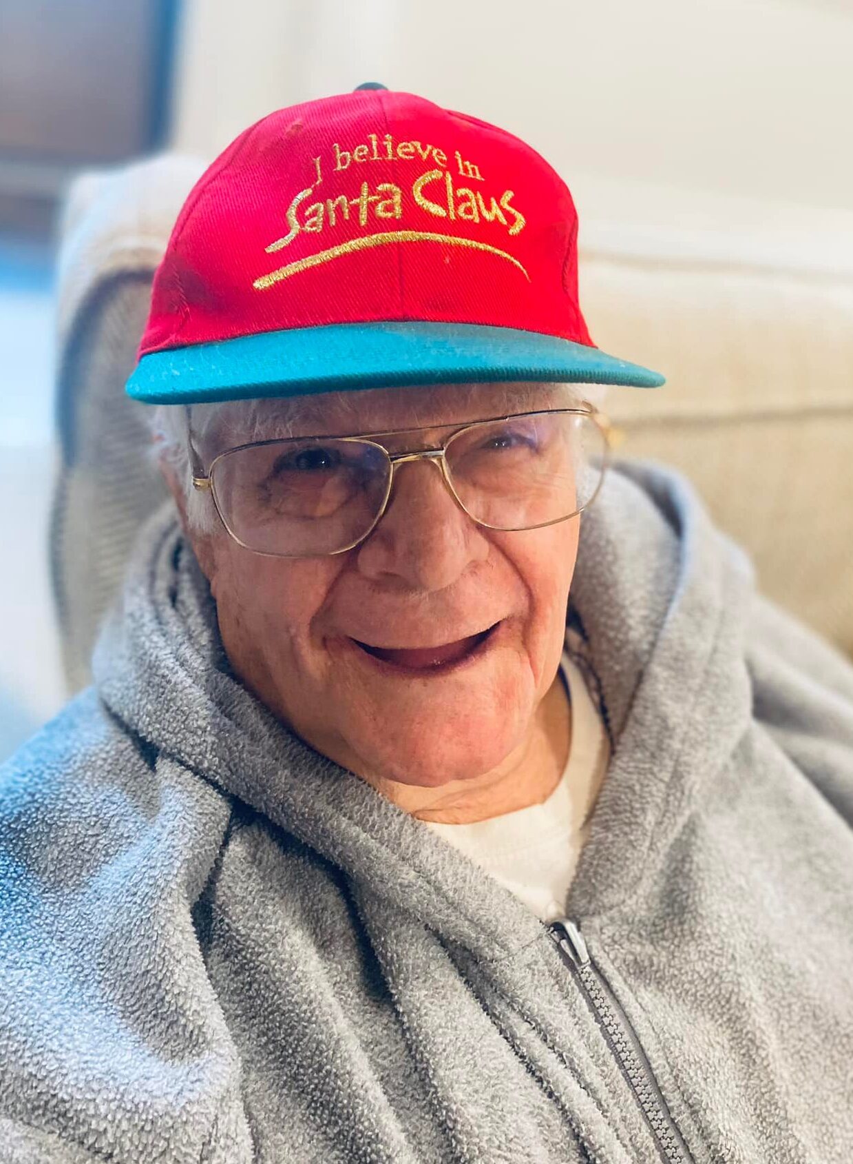 Elderly man wearing a red hat and smiling