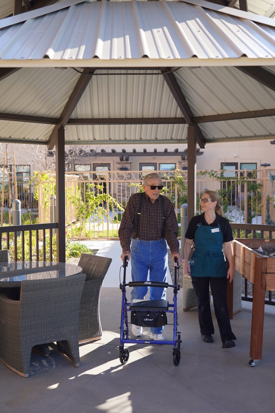 Resident assisted by staff in outdoor area