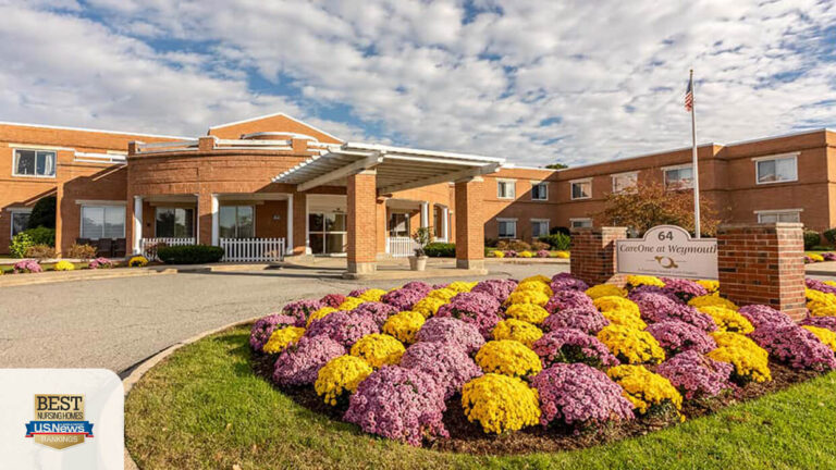 Entrance of CareOne at Lowell with vibrant flower beds