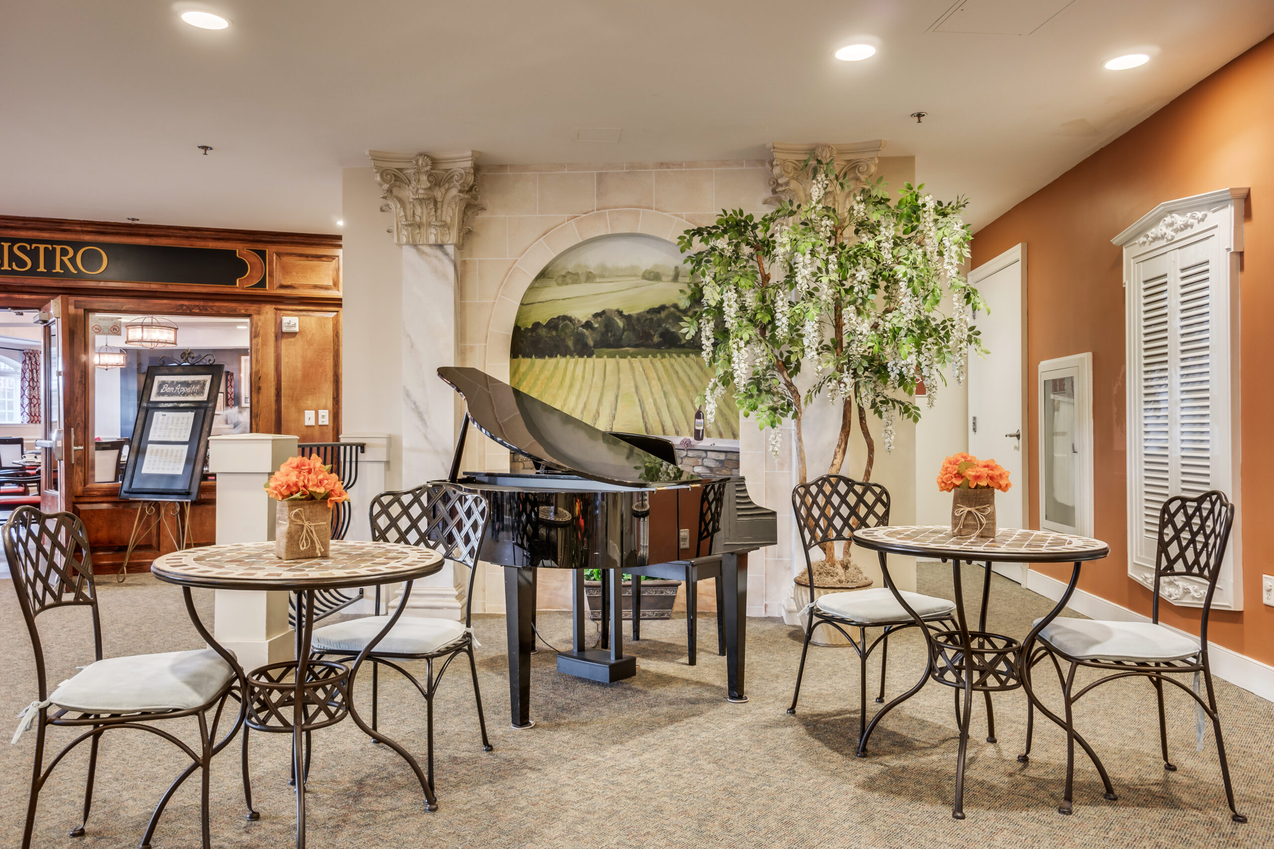 Common area with a piano and bistro tables