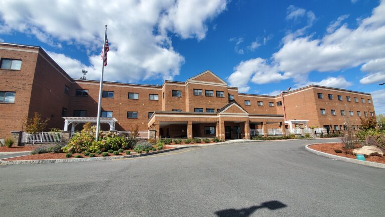 Exterior view of the assisted living facility with garden and flag