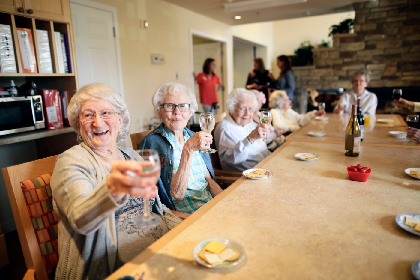 Residents celebrating with drinks at a communal table
