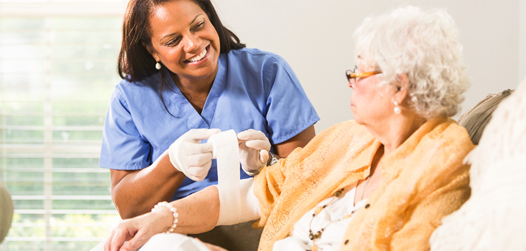 A caregiver assisting a senior with a bandage