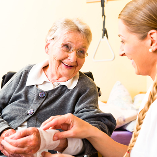 Caregiver assisting a smiling resident indoors