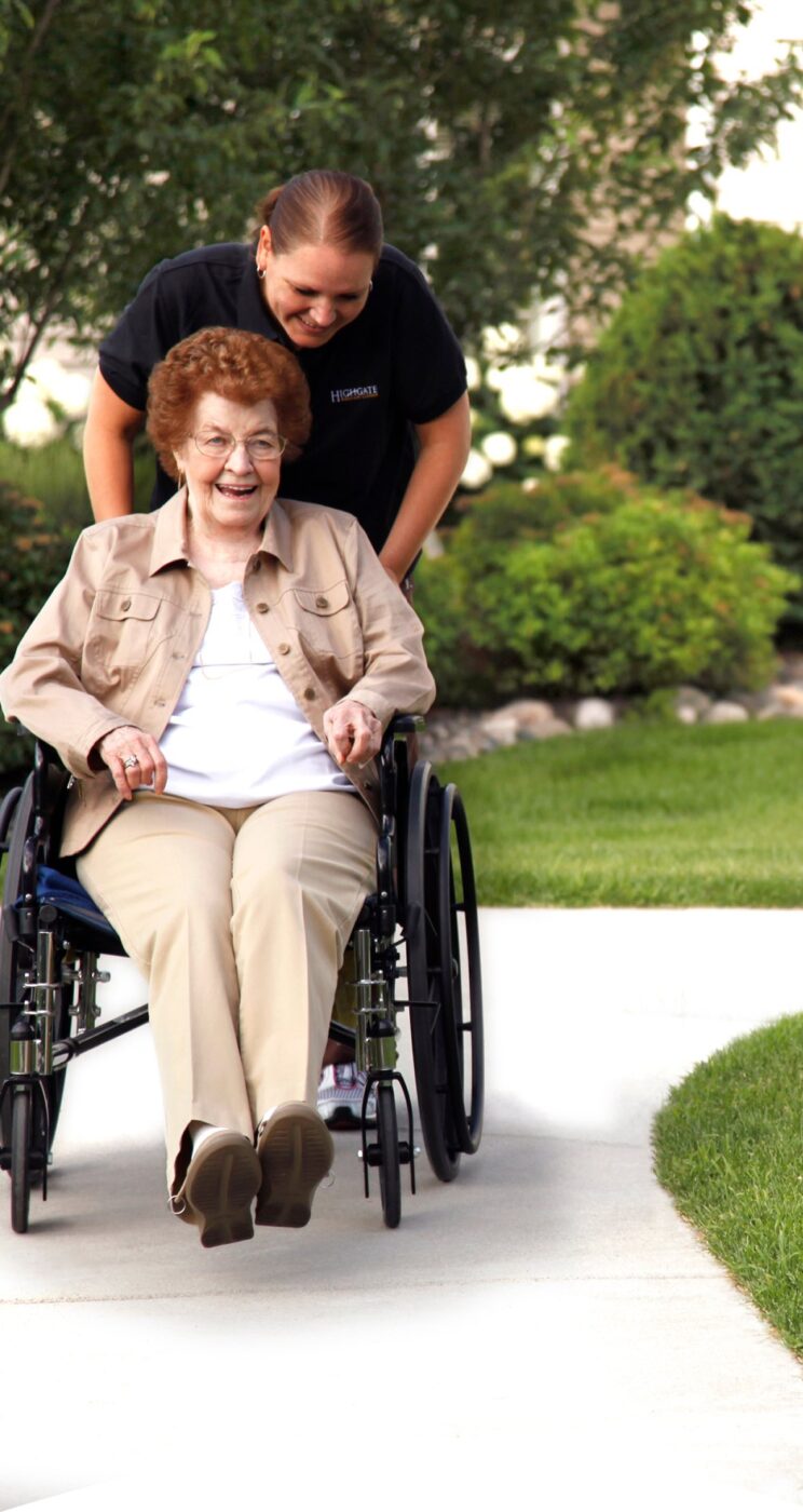 Resident enjoying a walk in the garden with staff assistance