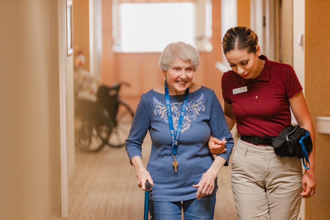 A caregiver assisting a resident in a hallway