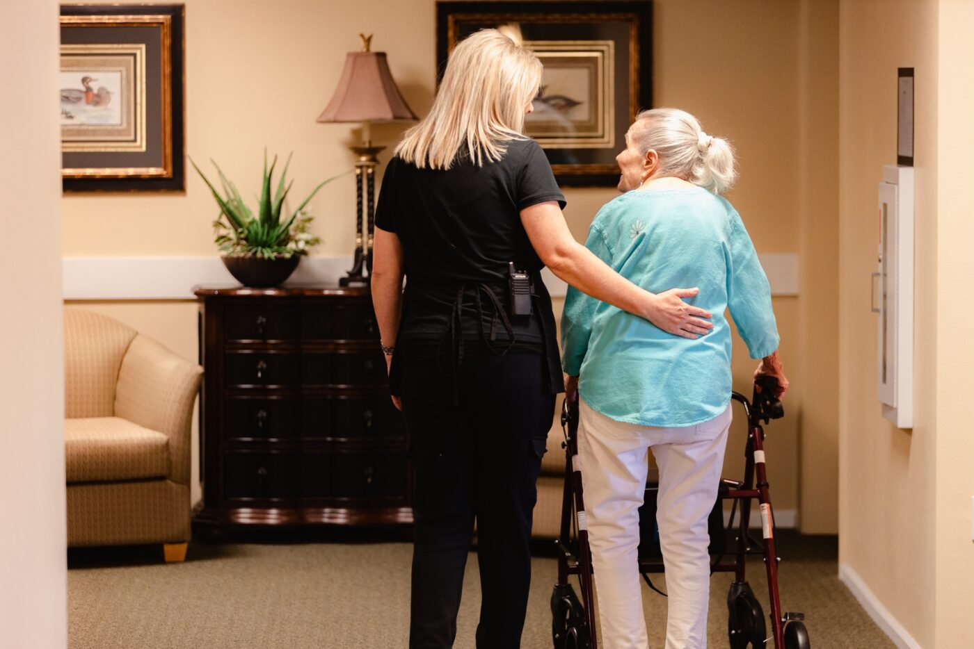 Staff assisting a resident in a hallway