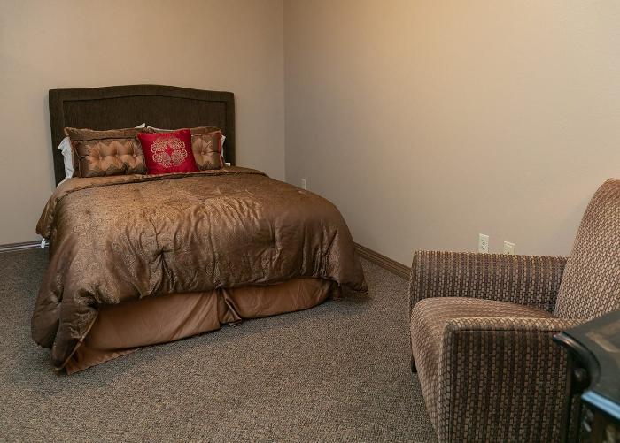 Cozy private resident room with a bed and chair