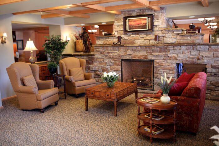 Cozy sitting area with stone fireplace and armchairs