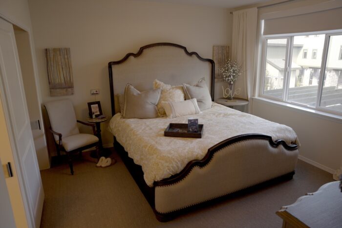 Cozy bedroom setup with bed, chair, and decorations