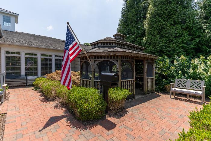 Outdoor gazebo with American flag in a landscaped area