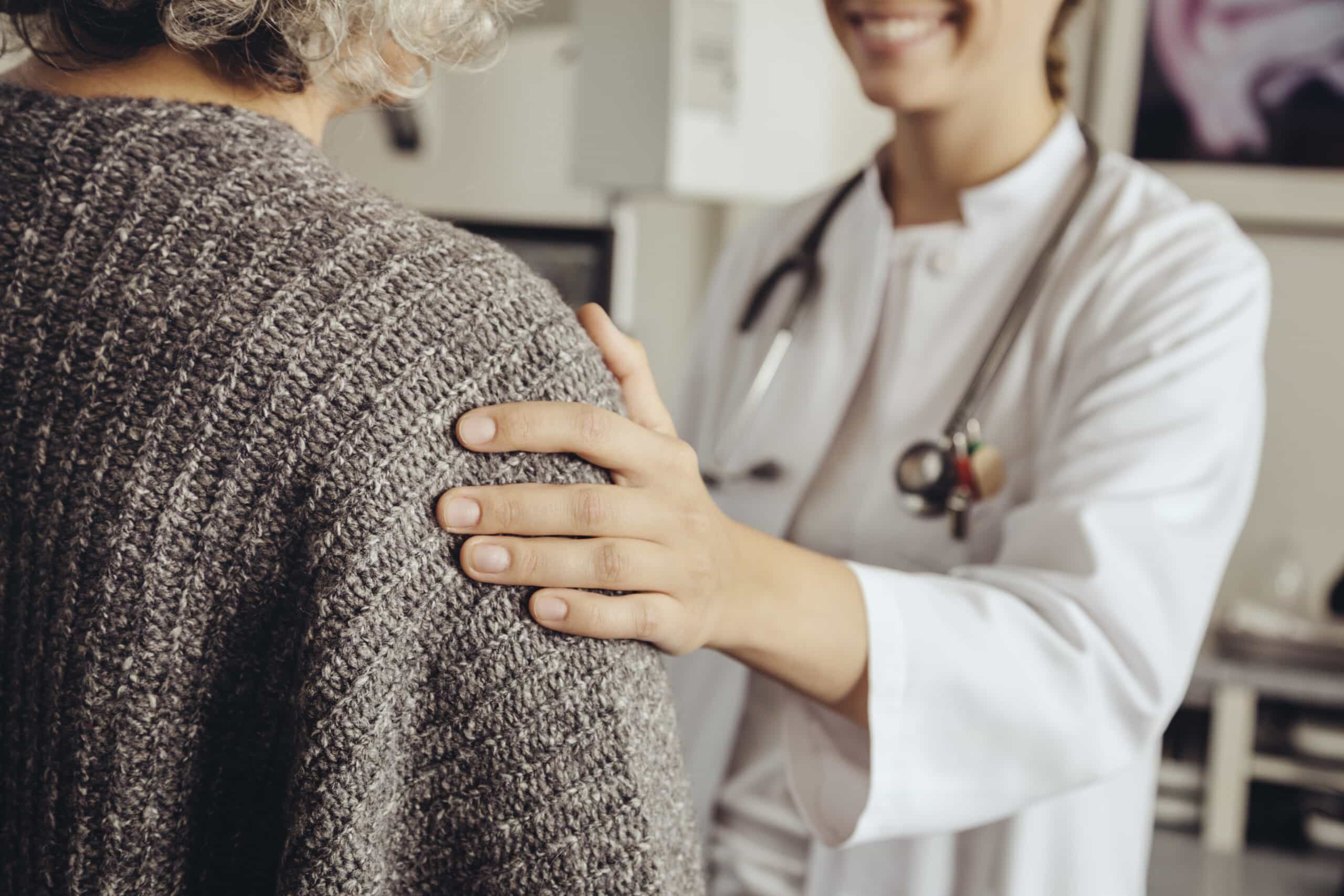 A caregiver assisting a senior resident in a warm setting