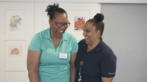 Two staff members smiling together