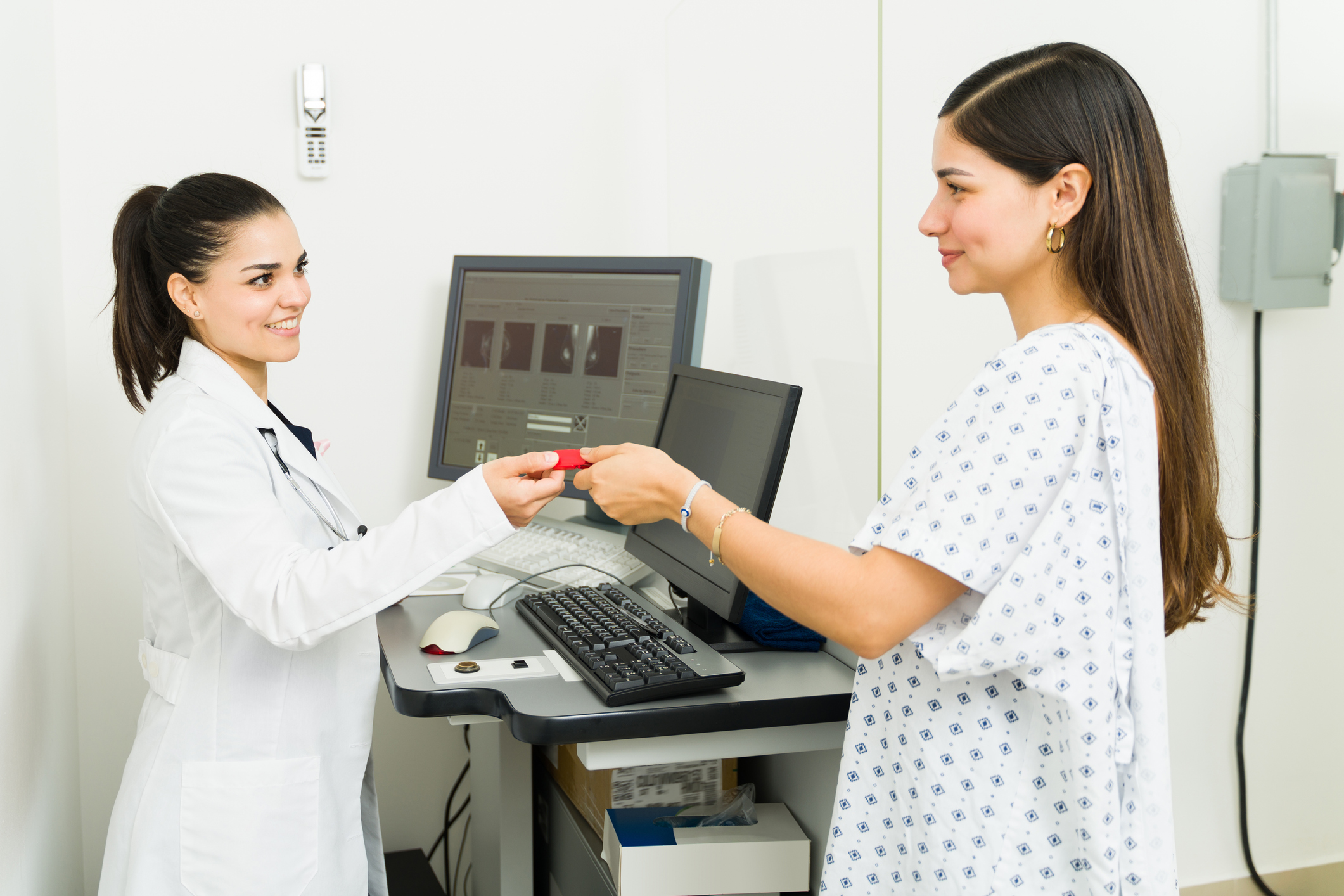 A doctor handing a red object to a patient in a clinic