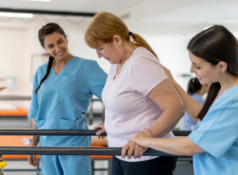 Residents participating in physical therapy with staff assistance